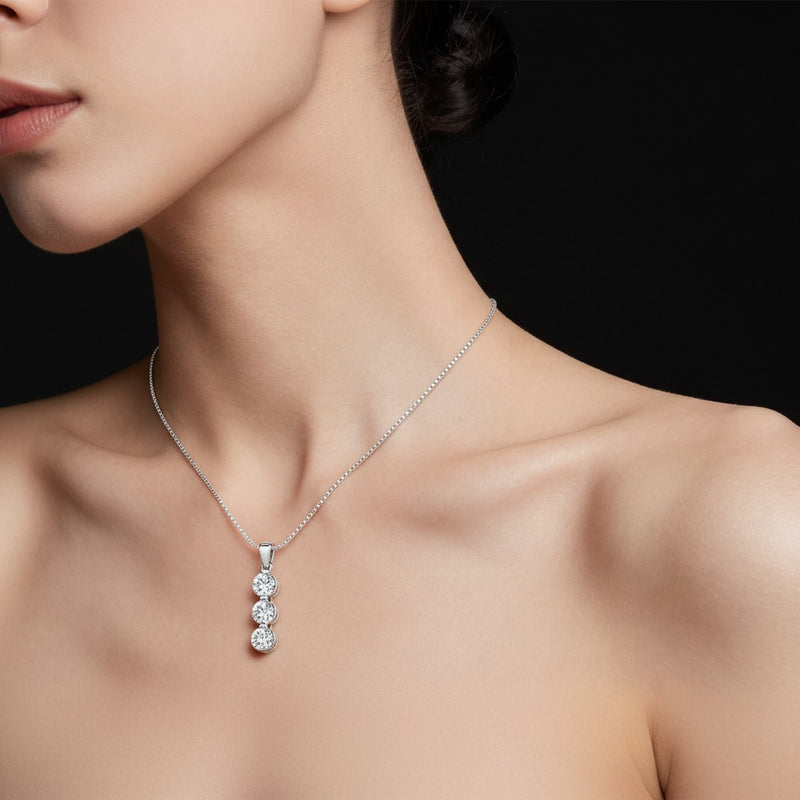 Model wearing round three stone pendant