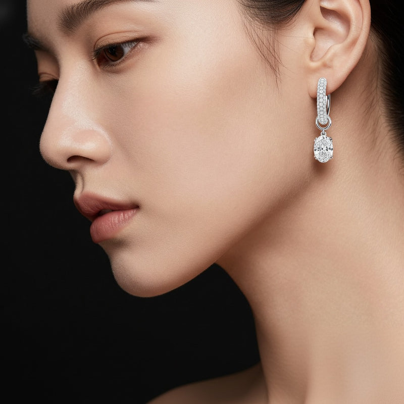 Model wearing oval dangle earrings